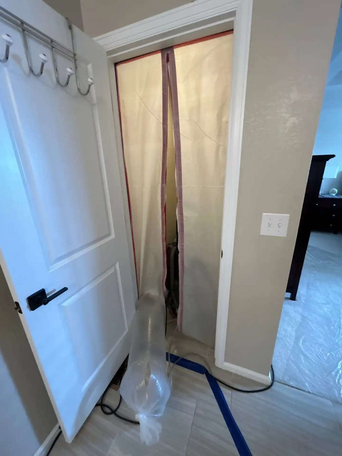 Zippered plastic containment door across a bedroom doorway